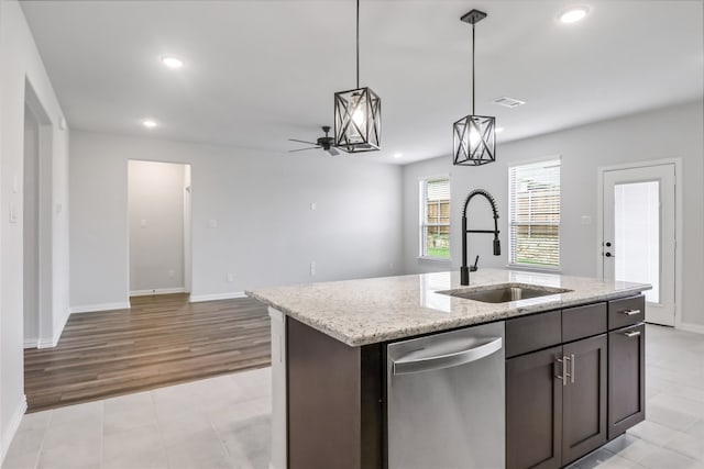 kitchen featuring light hardwood / wood-style flooring, decorative light fixtures, sink, a center island with sink, and stainless steel dishwasher