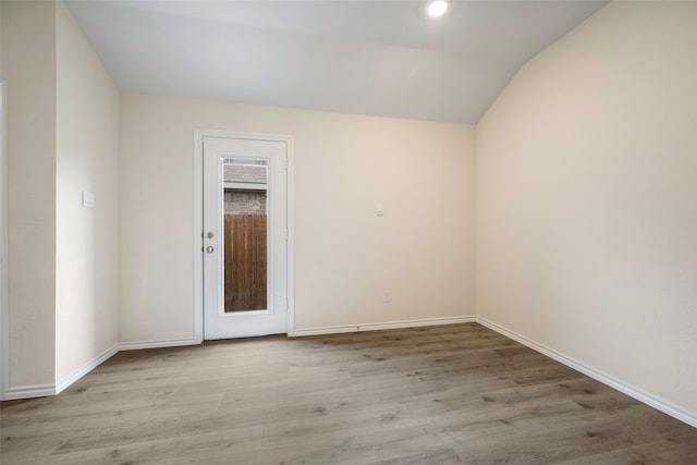 empty room with wood-type flooring and lofted ceiling