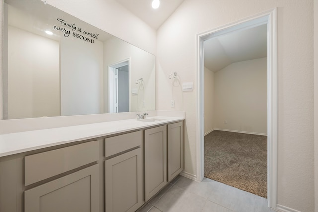 bathroom featuring tile patterned flooring, lofted ceiling, and vanity