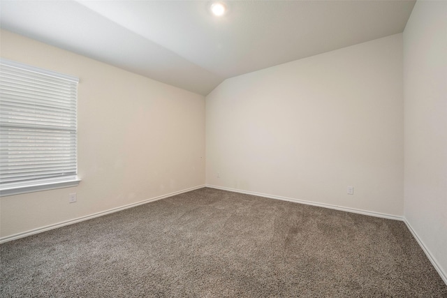 carpeted spare room featuring lofted ceiling