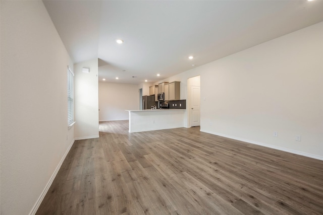 unfurnished living room featuring lofted ceiling and hardwood / wood-style flooring