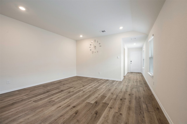 spare room featuring hardwood / wood-style flooring and vaulted ceiling