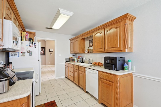 kitchen featuring sink, white appliances, and light tile patterned floors