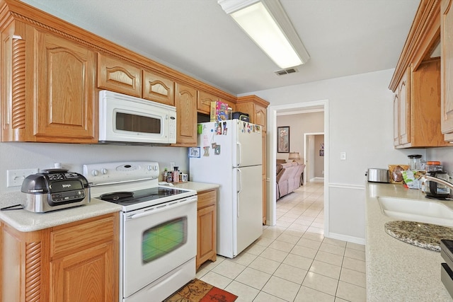 kitchen featuring sink, white appliances, and light tile patterned floors