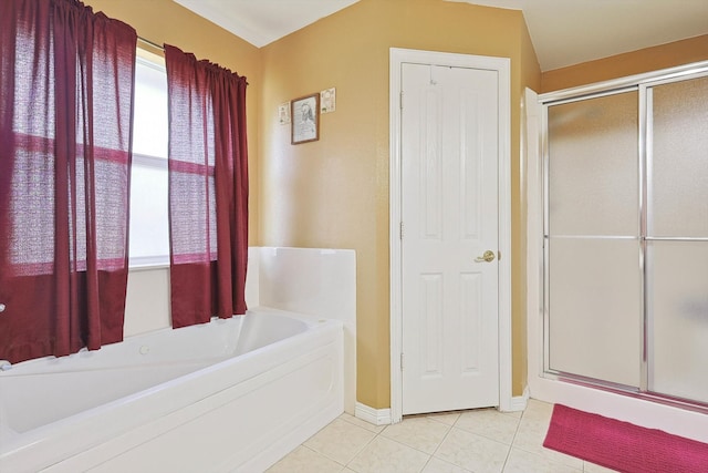 bathroom with tile patterned flooring, separate shower and tub, and a healthy amount of sunlight