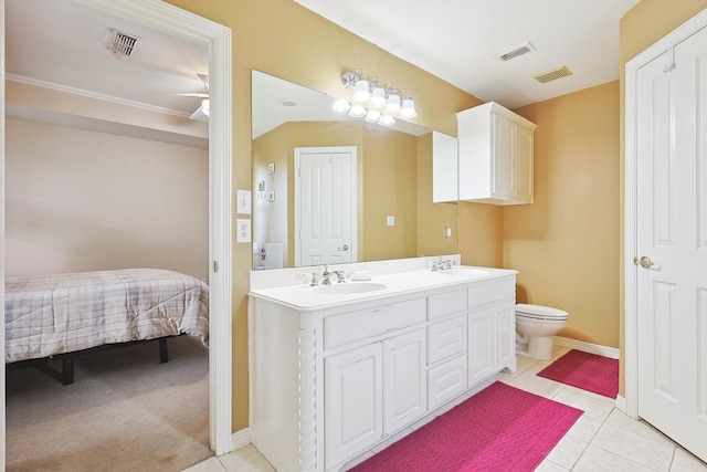 bathroom featuring tile patterned flooring, toilet, and dual bowl vanity