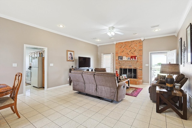 living room featuring ceiling fan, brick wall, a brick fireplace, and crown molding