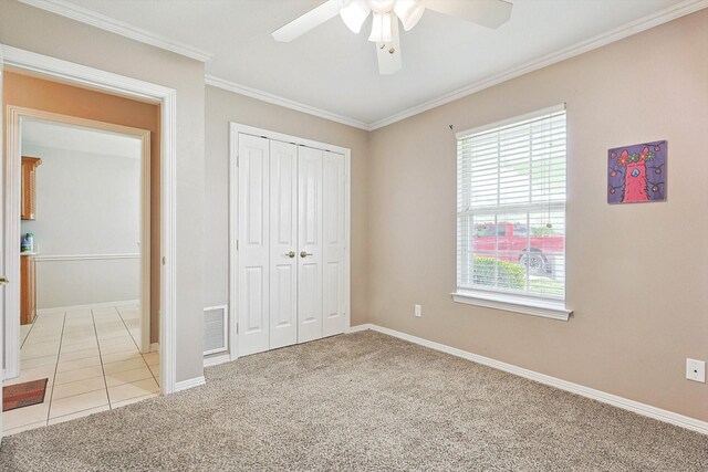 unfurnished bedroom featuring ornamental molding, light carpet, a closet, and ceiling fan