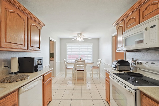 kitchen featuring ceiling fan, white appliances, and light tile patterned floors