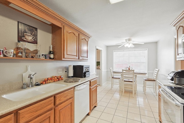 kitchen with sink, white appliances, light tile patterned floors, and ceiling fan