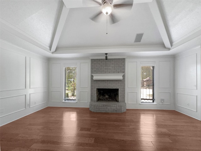 unfurnished living room featuring a brick fireplace, dark wood-type flooring, lofted ceiling with beams, and ceiling fan