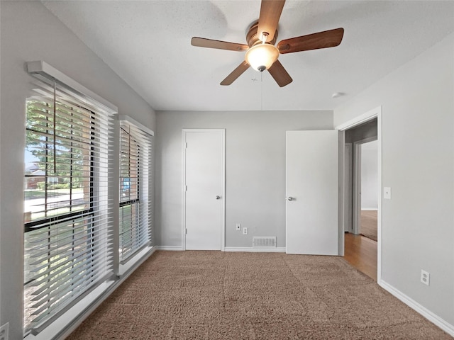 unfurnished bedroom with carpet flooring, ceiling fan, and a closet