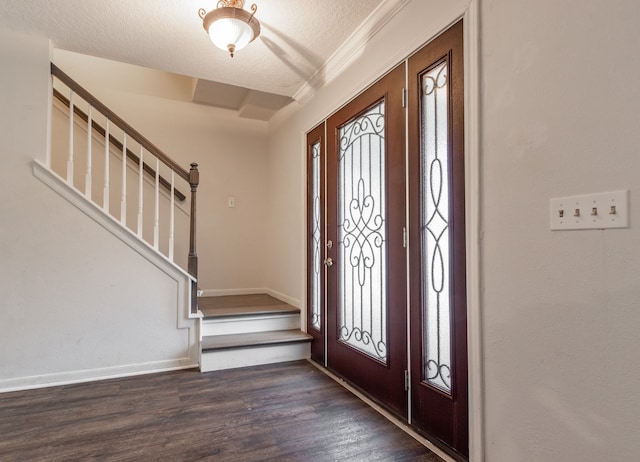 foyer featuring ornamental molding, a textured ceiling, and hardwood / wood-style flooring