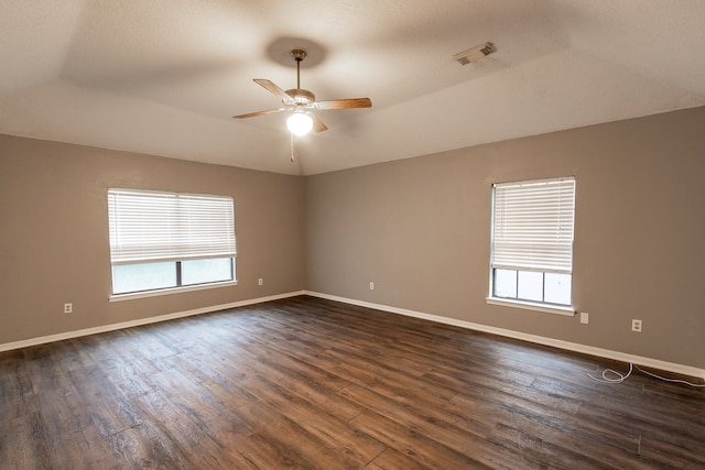 empty room with a healthy amount of sunlight, hardwood / wood-style flooring, and ceiling fan