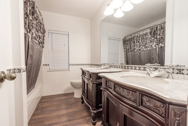 full bathroom featuring wood-type flooring, double sink vanity, toilet, and shower / bath combination with curtain