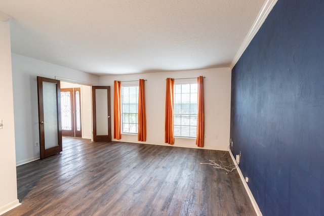 unfurnished room featuring a textured ceiling, ornamental molding, wood-type flooring, and french doors