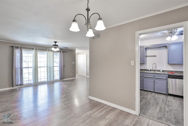 unfurnished dining area featuring crown molding, sink, ceiling fan with notable chandelier, and light hardwood / wood-style floors