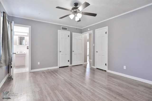 unfurnished bedroom featuring ensuite bathroom, ceiling fan, light wood-type flooring, crown molding, and sink