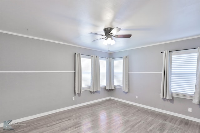 empty room with ceiling fan, plenty of natural light, ornamental molding, and light hardwood / wood-style floors