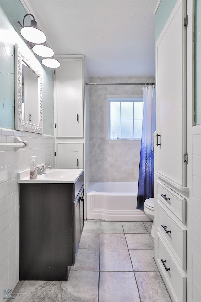 full bathroom with toilet, shower / bath combination with curtain, tile patterned floors, tile walls, and vanity