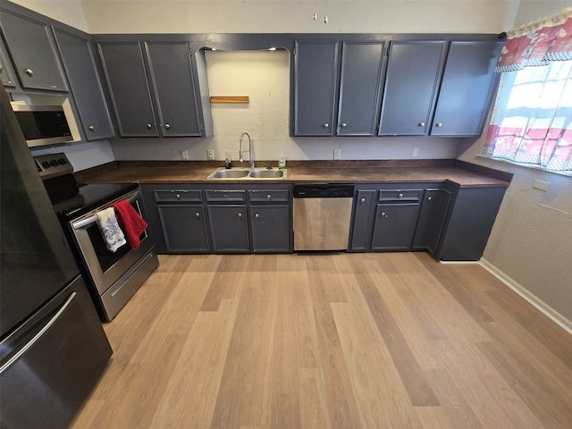 kitchen featuring appliances with stainless steel finishes, light hardwood / wood-style floors, and sink