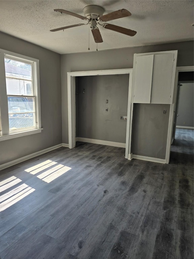 unfurnished bedroom featuring a textured ceiling, dark wood-type flooring, and ceiling fan