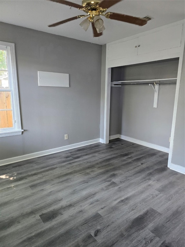 unfurnished bedroom featuring dark wood-type flooring, ceiling fan, and a closet