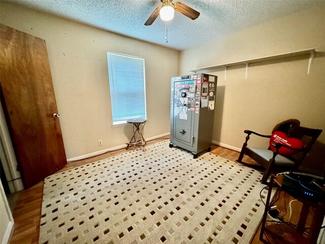 interior space featuring ceiling fan, light hardwood / wood-style floors, and a textured ceiling