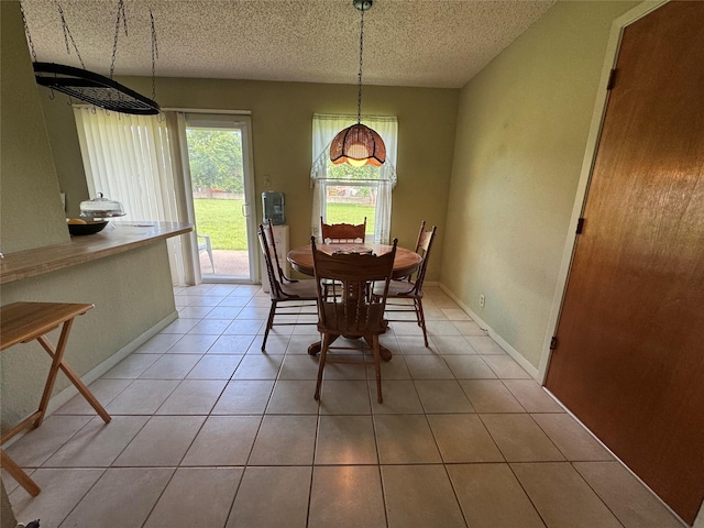 4506 Azalea Dr, Granbury, TX 76049 - dining room with a textured ceiling, light tile patterned flooring, and baseboards