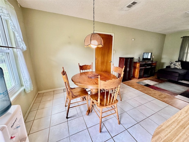 tiled dining room with a textured ceiling and washer / clothes dryer