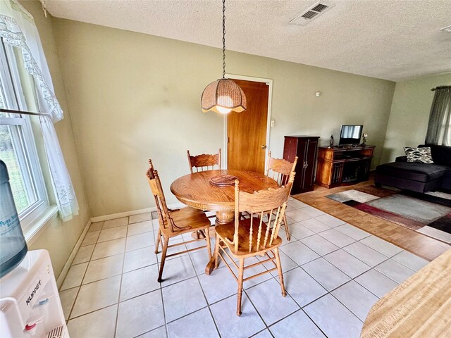 tiled dining room with a textured ceiling and washer / clothes dryer