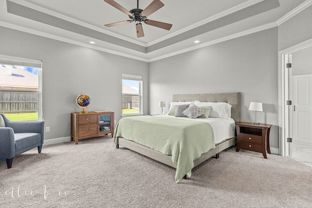 carpeted bedroom featuring multiple windows, crown molding, and a tray ceiling