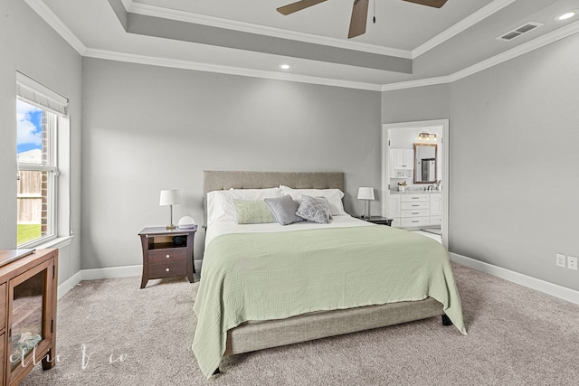 bedroom featuring ceiling fan, ensuite bath, crown molding, a raised ceiling, and carpet