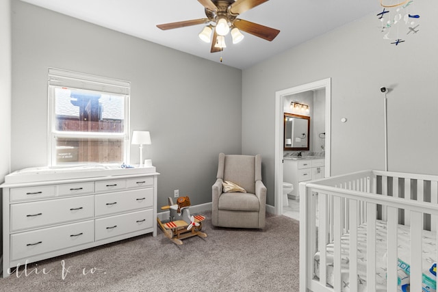 bedroom with light carpet, connected bathroom, a nursery area, and ceiling fan