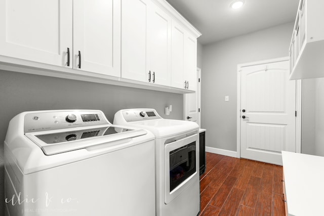 clothes washing area featuring cabinets, dark hardwood / wood-style flooring, and independent washer and dryer