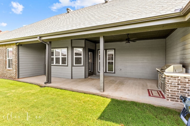 back of house featuring exterior kitchen, a patio area, a lawn, and ceiling fan