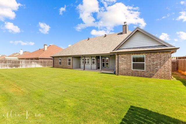 back of house featuring a patio area and a yard