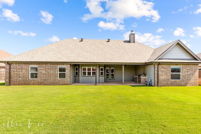 rear view of property featuring a patio and a yard