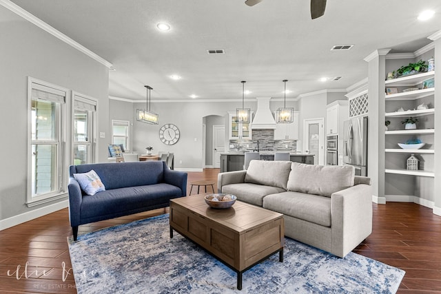 living room with ornamental molding, ceiling fan with notable chandelier, and hardwood / wood-style flooring