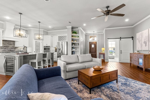 living room with beverage cooler, ceiling fan with notable chandelier, dark hardwood / wood-style flooring, and ornamental molding