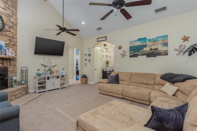 living room featuring a stone fireplace, carpet, ceiling fan, and high vaulted ceiling