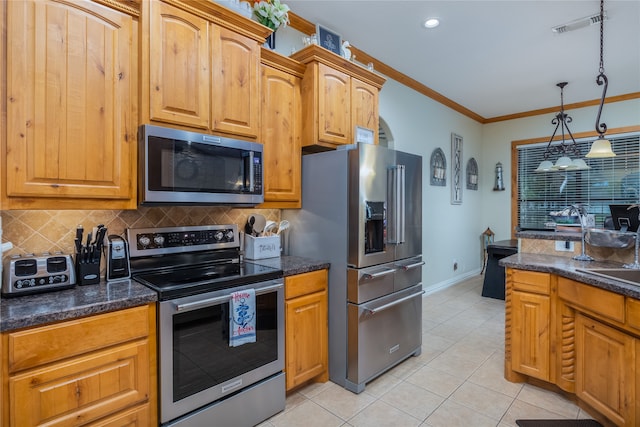 kitchen featuring hanging light fixtures, appliances with stainless steel finishes, light tile patterned floors, and backsplash