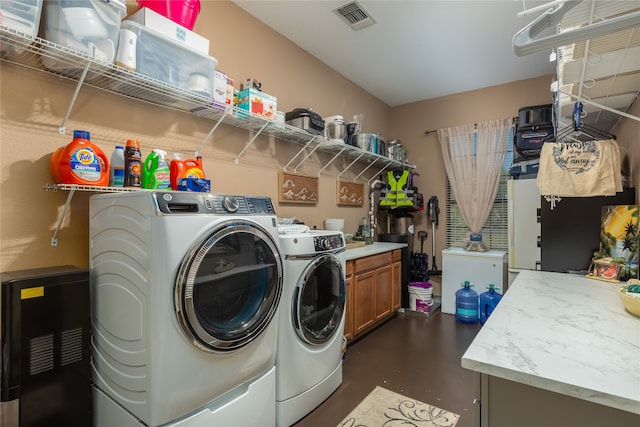 laundry area featuring washer and dryer and cabinets