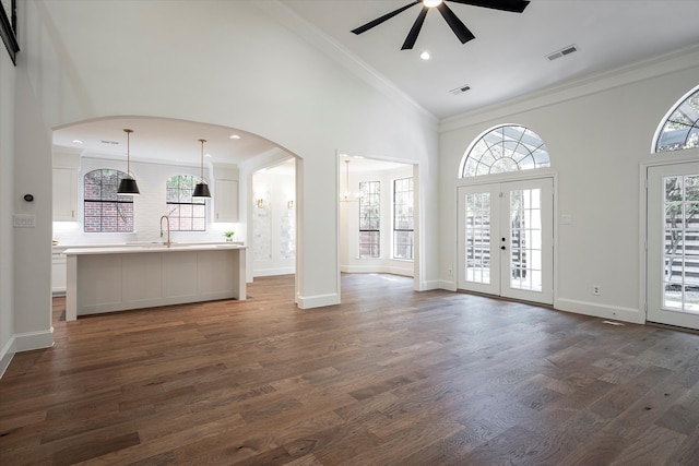 unfurnished living room featuring sink, french doors, dark hardwood / wood-style floors, ceiling fan, and ornamental molding