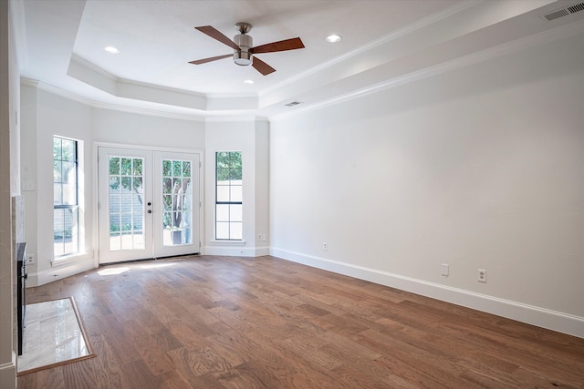 unfurnished room featuring hardwood / wood-style flooring, a raised ceiling, french doors, and ceiling fan