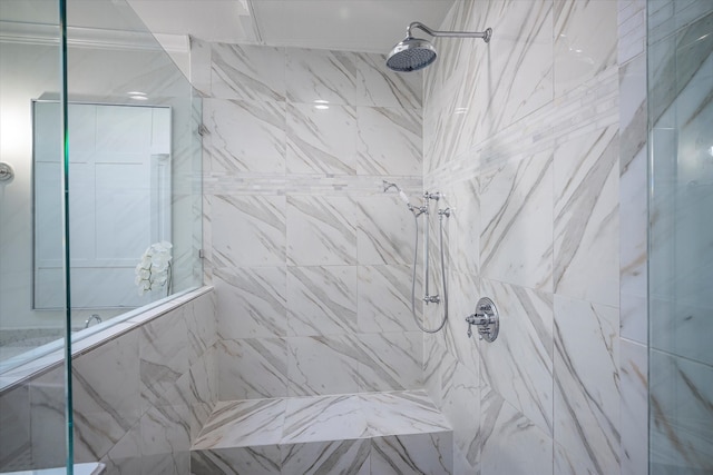 bathroom featuring ornamental molding and a tile shower