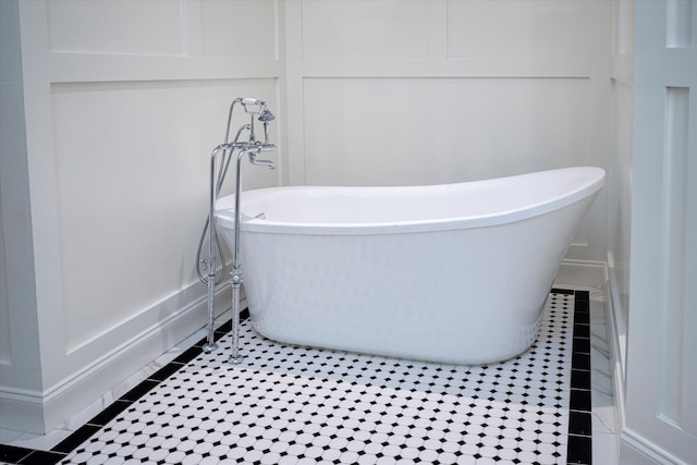 bathroom with a washtub and tile patterned floors