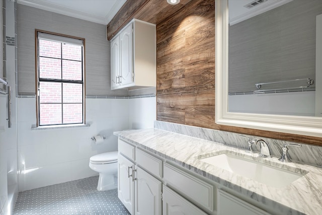 bathroom featuring vanity, toilet, tile patterned floors, and tile walls