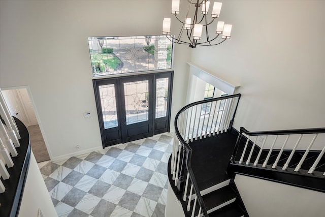 tiled foyer with a chandelier and a towering ceiling