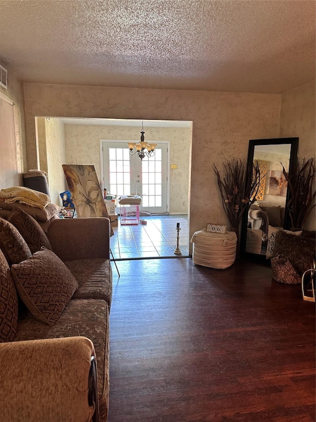 living room with hardwood / wood-style floors, a chandelier, and a textured ceiling